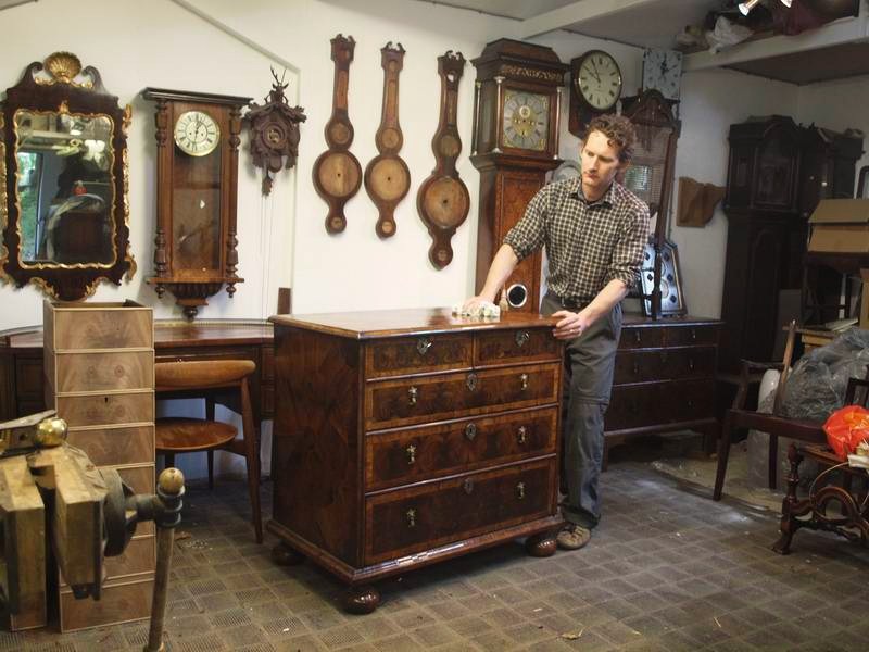 Picture of workshop interior, various objects including oyster veneered walnut period chest.